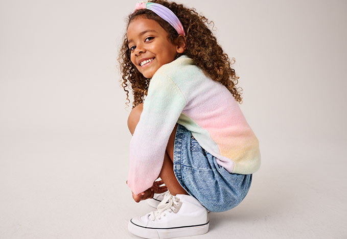 M&auml;dchen mit bunter Strickjacke und Jeans Rock 